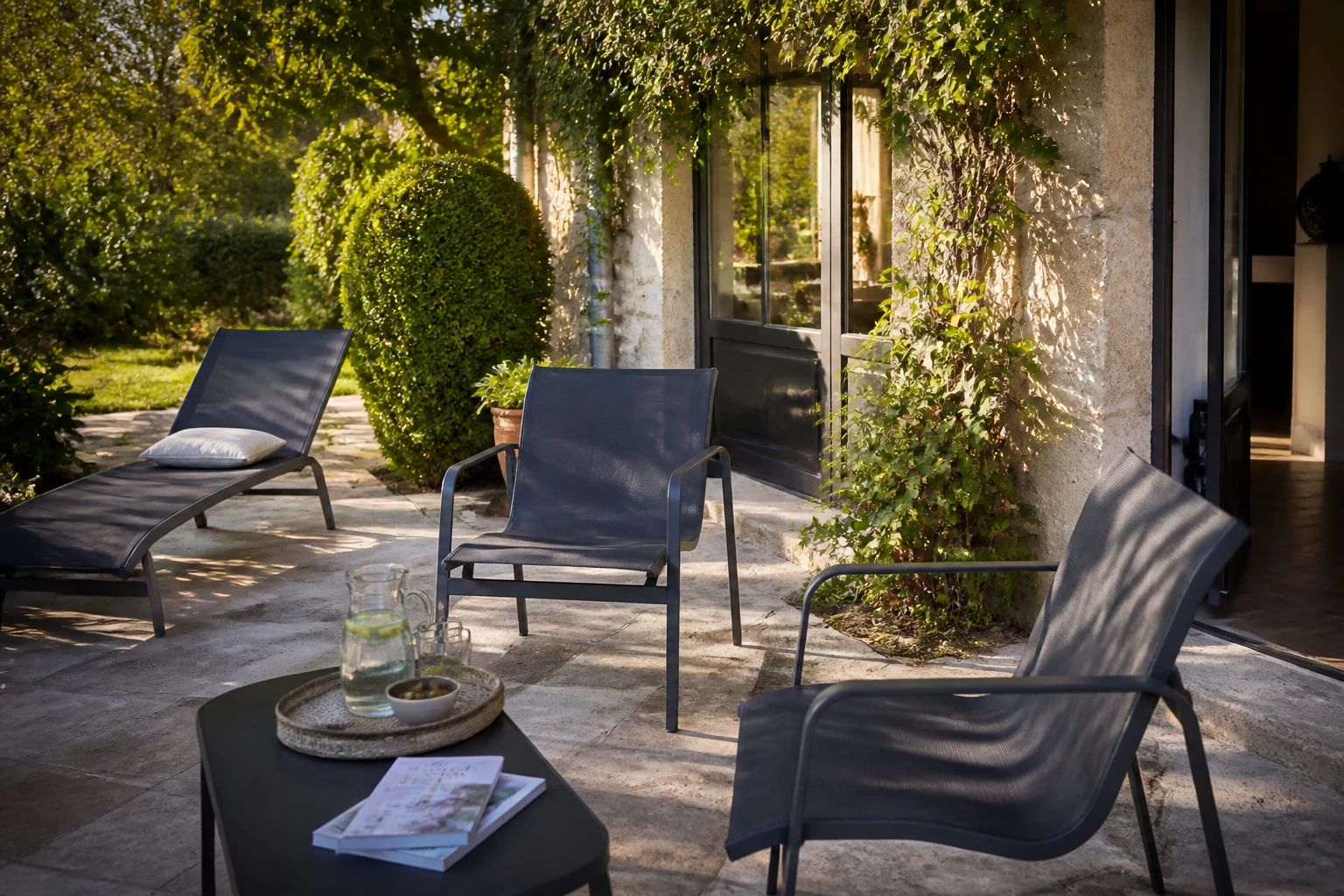 Fauteuils de jardin en toile textilène installés sur une terrasse ensoleillée